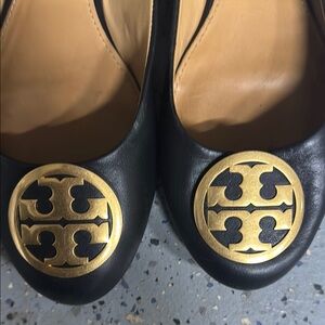 Tory Burch Black and Gold Flats with Rounded Toe and Decorative Emblem